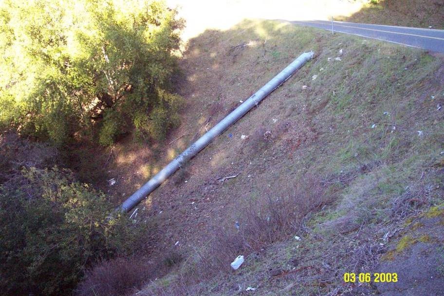 A culvert near the top of a hill has a long extension, so the water travels in the extension to the bottom of the hill, eliminating erosion potential.