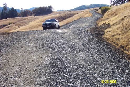 A smooth road with two rolling dips in a grassy area.